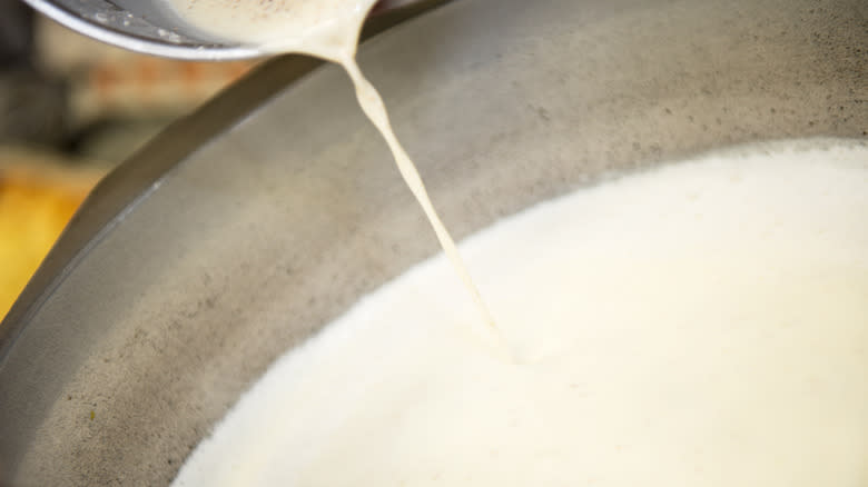 milk pouring into big bowl