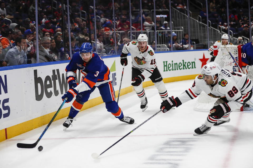 New York Islanders defenseman Adam Pelech (3) fights for the puck against Chicago Blackhawks center Andreas Athanasiou (89) during the first period of an NHL hockey game on Sunday, Dec. 4, 2022, in Elmont, N.Y. (AP Photo/Eduardo Munoz Alvarez)