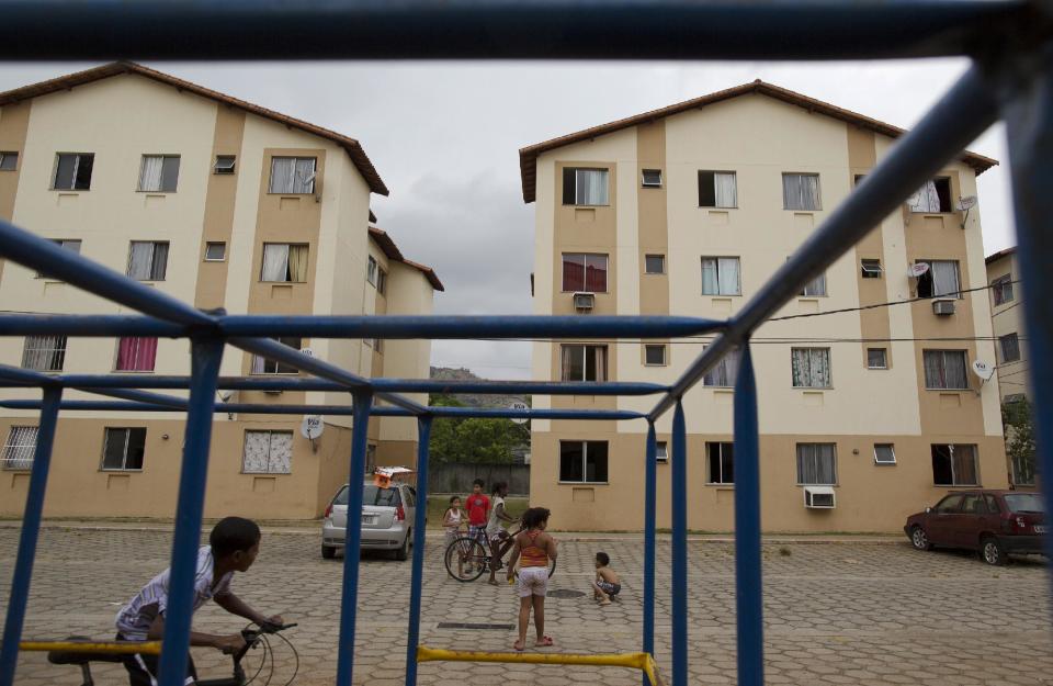 In this Feb. 16, 2014 photo, children play at the Condominio Oiti project in the suburb of Campo Grande, Rio de Janeiro, Brazil. Inaugurated in 2011, the project houses nearly 200 families relocated from slums throughout the city. (AP Photo/Leo Correa)