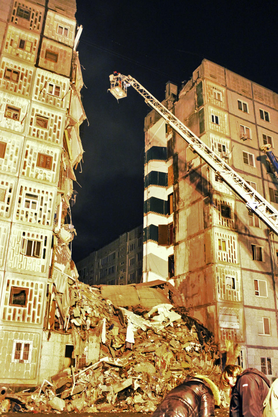 In this photo distributed by the Astrakhan branch of the Ministry for Emergency Situations, Emergency Situations Ministry rescuers inspect debris of an apartment building early Tuesday morning, Feb. 28, 2012, after it exploded on Monday, Feb. 27, 2012, in Astrakhan, Russia. The nine-story apartment building collapsed in an explosion caused by natural gas, killing several people and while injuring 12 others. (AP Photo/ Astrakhan Branch, Ministry of Emergency Situations Press Service)