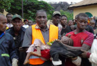 Rescuers carry a child who survived after a mudslide at a rubbish landfill in the Dar Es Salam neighbourhood, on the outskirts of the capital Conakry, Guinea, August 22, 2017. REUTERS/Saliou Samb