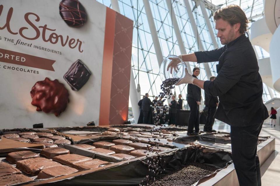 Brian Walsh dumps chocolate covered almonds into the chocolate gift box during Russell Stover Chocolates’ attempt to break the Guinness World Record for the largest box of chocolate.