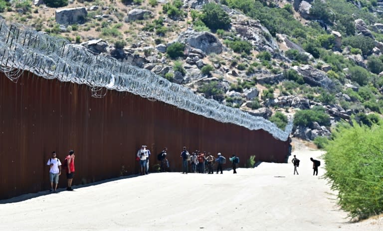 Unos migrantes caminan del lado estadounidense del muro fronterizo con México en Jacumba Hot Springs, California, el 5 de junio de 2024 (Frederic J. Brown)