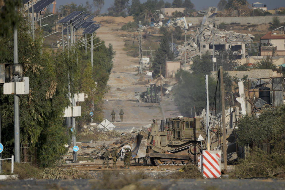 FILE - Israeli soldiers stand on Salah al-Din road in central Gaza Strip on Friday, Nov. 24, 2023, as the temporary ceasefire went into effect. The Israeli military has rounded up hundreds of Palestinians across the northern Gaza Strip, separating families and forcing men to strip to their underwear before trucking some to an undisclosed location. The roundups have laid bare an emerging tactic in Israel's ground offensive in Gaza, experts say, as the military seeks to solidify control in evacuated areas in the north and collect intelligence about Hamas operations nearly 10 weeks after the group's deadly Oct. 7 attack on southern Israel. (AP Photo/Hatem Moussa, File)