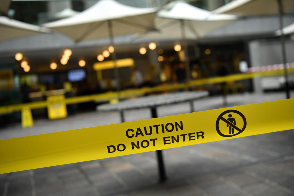 'Caution do not enter' reads yellow tape stretched across an outdoor seating area.