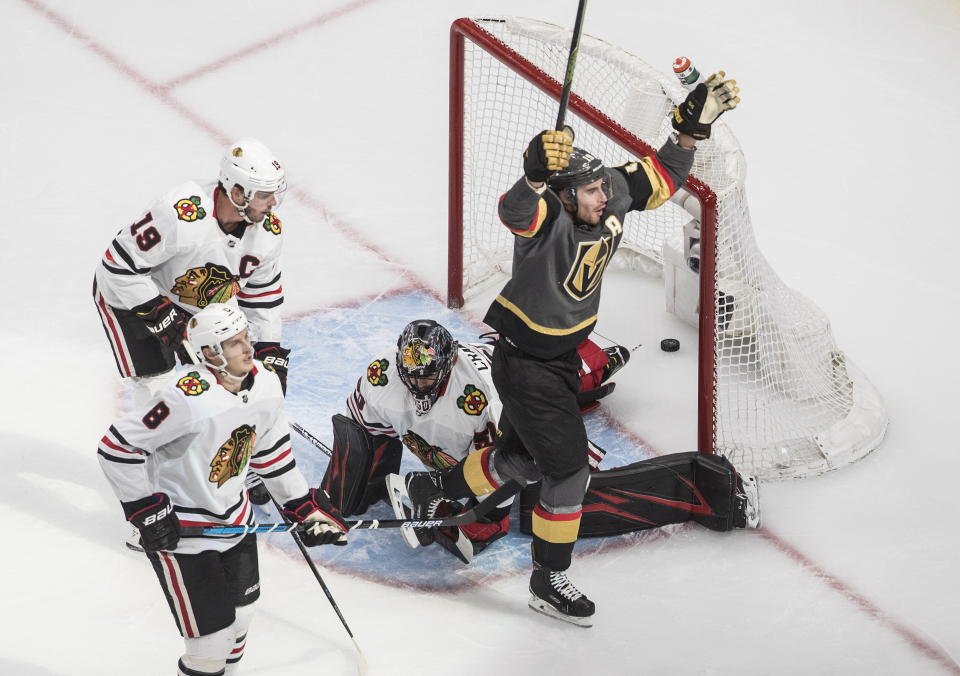 Vegas Golden Knights' Reilly Smith (19) scores on Chicago Blackhawks goalie Corey Crawford (50) as Blackhawks' Jonathan Toews (19) and Dominik Kubalik (8) react during overtime in an NHL hockey Stanley Cup first-round playoff series, Thursday, Aug. 13, 2020, in Edmonton, Alberta. (Jason Franson/The Canadian Press via AP)