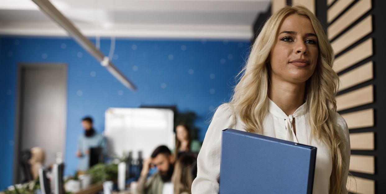 a woman leaving office holding a folder