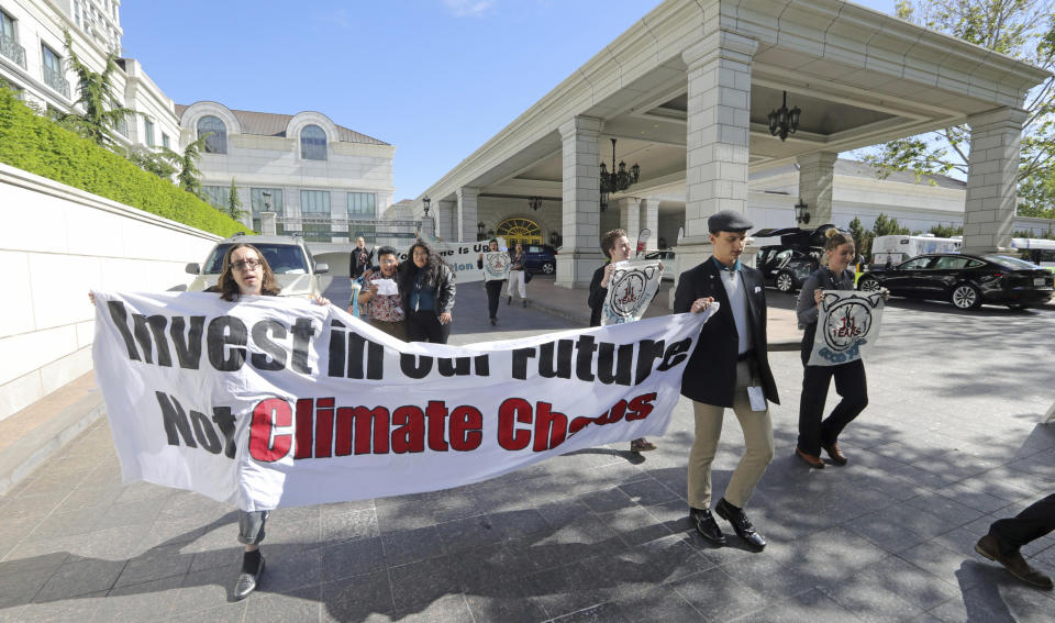 About 25 protesters leave after interrupting a energy conference where U.S. Energy Secretary Rick Perry spoke Thursday, May 30, 2019, in Salt Lake City. Perry says the Trump administration is committed to making fossil fuels cleaner rather than imposing "draconian" regulations on oil, gas and coal. Perry made his remarks during a speech at an energy conference in Salt Lake City hosted by Utah Gov. Gary Herbert. (AP Photo/Rick Bowmer)