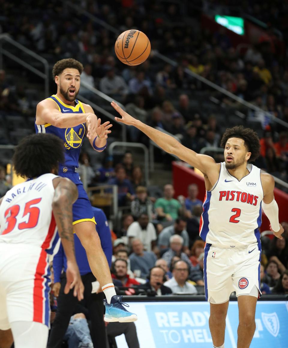 Golden State Warriors guard Klay Thompson (11) passes against Detroit Pistons guard Cade Cunningham (2) during first-quarter action at Little Caesars Arena in Detroit on Monday, Nov. 6, 2023.