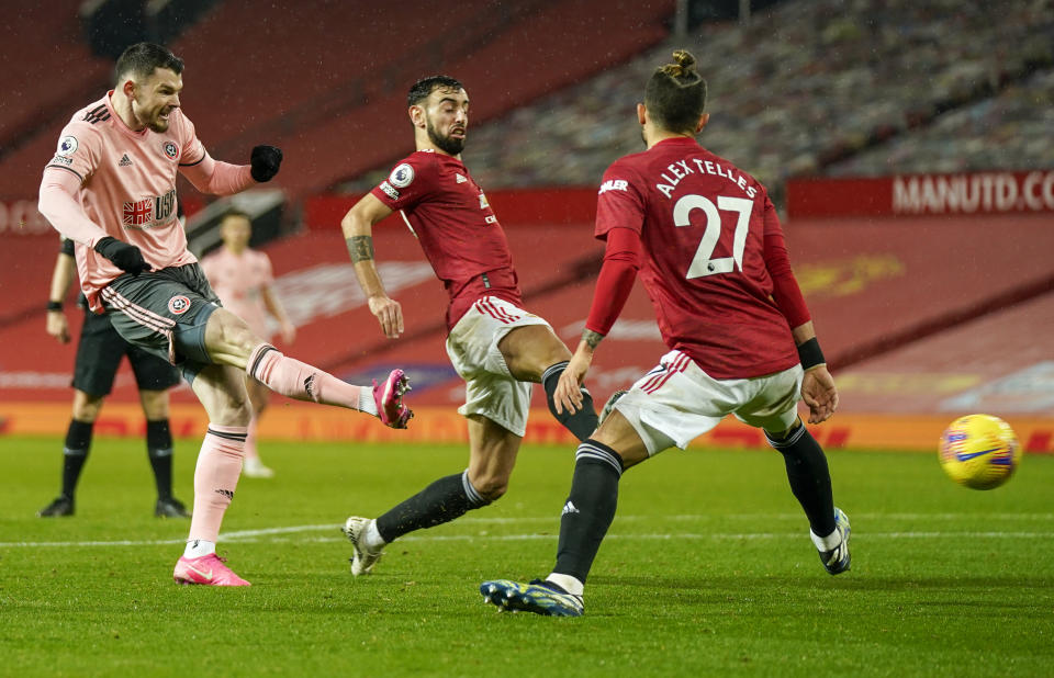 Sheffield United's Oliver Burke, left, scores his team's second goal during the English Premier League soccer match against Manchester United. (AP Photo/Tim Keeton,Pool)