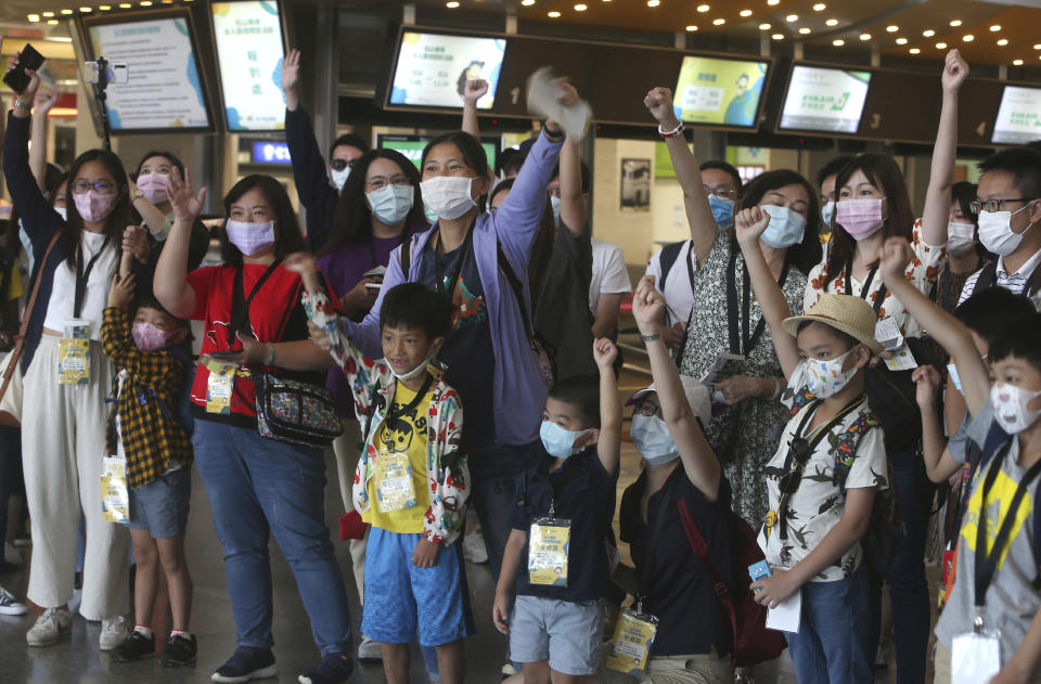 Participants vie to answer quiz questions during a mock trip abroad at Taipei Songshan Airport in Taipei, Taiwan, Tuesday, July 7, 2020. Dozens of would-be travelers acted as passengers in an activity organized by Taiwan’s Civil Aviation Administration to raise awareness of procedures to follow when passing through customs and boarding their plane at Taipei International Airport. (AP Photo/Chiang Ying-ying)