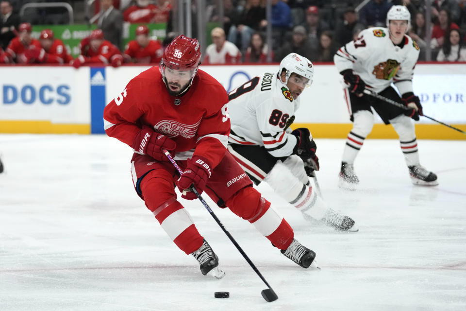 Detroit Red Wings defenseman Jake Walman (96) protects the puck from Chicago Blackhawks center Andreas Athanasiou (89) in the third period of an NHL hockey game Wednesday, March 8, 2023, in Detroit. (AP Photo/Paul Sancya)