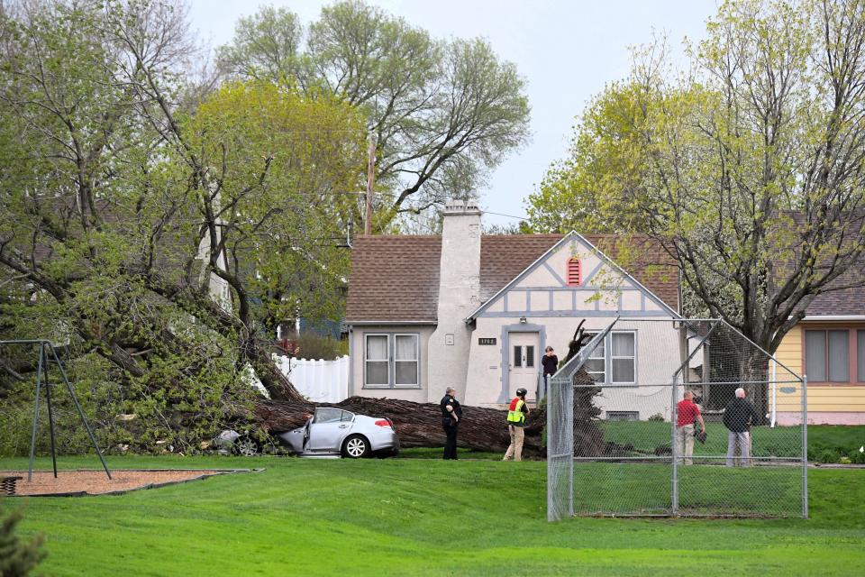 A massive tree is toppled on a vehicle at 26th Street and Norton Avenue on Thursday, May 12, 2022, in Sioux Falls.