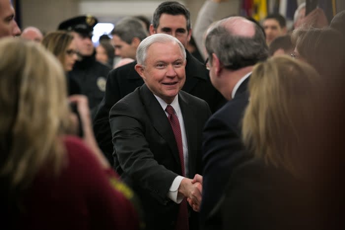 Former U.S. Attorney General Jeff Sessions shaking hands in a crowded room