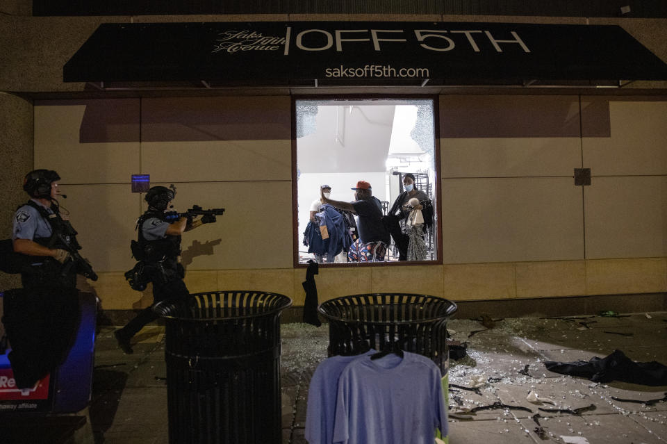 Police clear out and secure Saks OFF 5th Wednesday, Aug. 26, 2020 in Minneapolis. The Minneapolis mayor imposed a curfew Wednesday night and requested National Guard help after unrest broke out downtown following what authorities said was misinformation about the death of a Black homicide suspect. (Jeff Wheeler/Star Tribune via AP)