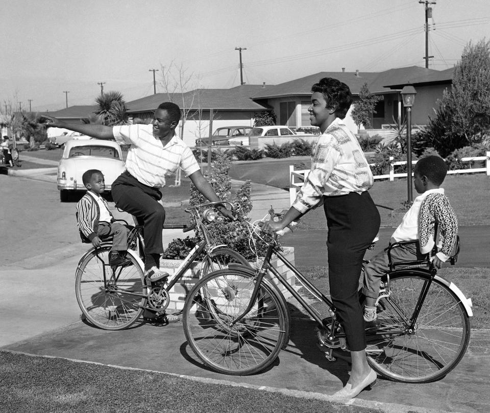 FILE - In this Wednesday, Dec. 12, 1962 file photo, Kenneth Kelly, an electrical engineer studying for his master's degree, points out his all-white neighborhood to his wife, Loretta, and sons David, 4, left, and Ronnie in Gardena, Calif. Kenneth C. Kelly, a Black electronics engineer whose antenna designs contributed to the race to the moon, made satellite TV and radio possible and helped NASA communicate with Mars rovers and search for extraterrestrials, has died. The 92-year-old also worked to erase race barriers in the Navy, in California housing and on the newspaper comics pages. Kelly had Parkinson's disease before his death on Feb. 27, 2021 his son Ron Kelly said. (AP Photo/David F. Smith, File)