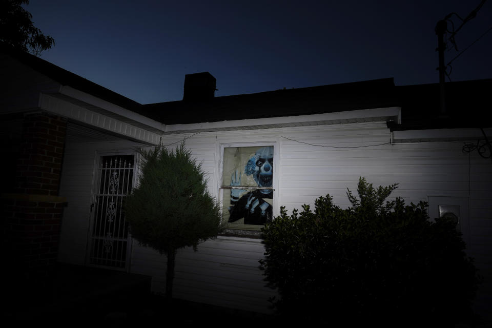 Shattered window glass and a clown are seen at the home of Charles Allan Keel, on Friday, June 24, 2022, in Trinity, Ala. Keel faces murder charges after the death of 51-year-old David Guess, after police say Keel shot him with a handgun in March. Guess’ death began with an argument over a car part. (AP Photo/Brynn Anderson)