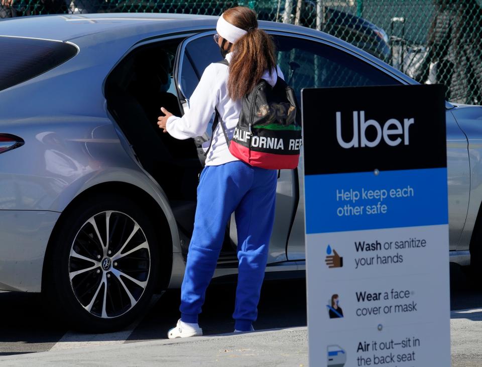 In this Nov. 13, 2020, file photo, a traveler rides in the back of an Uber vehicle at Los Angeles International Airport in Los Angeles.