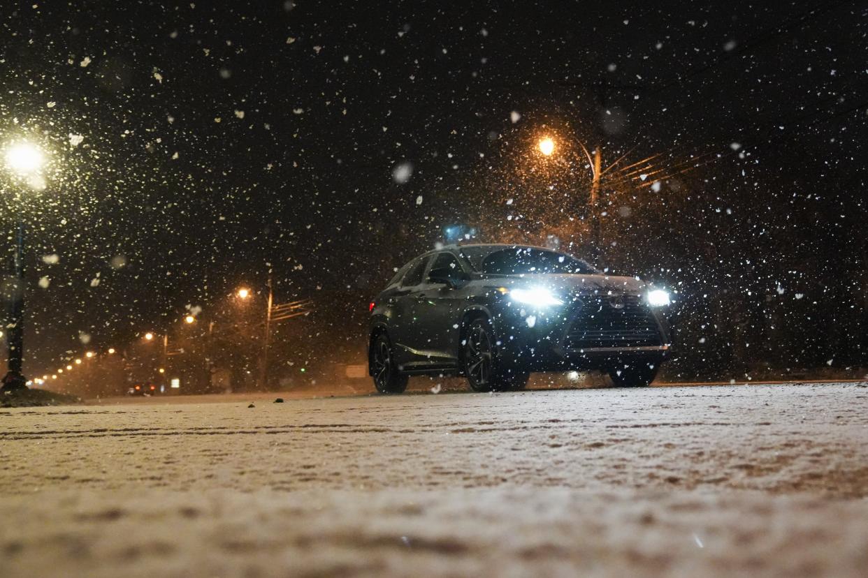 Sun., Jan. 16, 2022; Columbus, Ohio, USA; A car drives down along High Street as snow falls in Clintonville. Forecasts estimate Greater Columbus could see as much as six inches of snow overnight and into tomorrow.