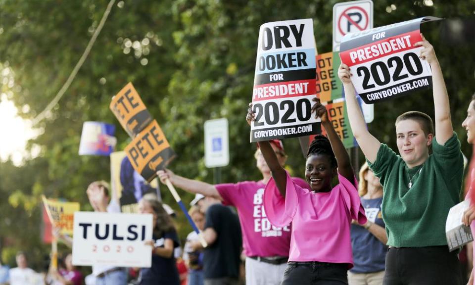 People hold up signs along First Avenue at an LGBTQ Presidential Forum in the Sinclair Auditorium on the Coe College campus in Cedar Rapids, Iowa, on Friday, 20 September.