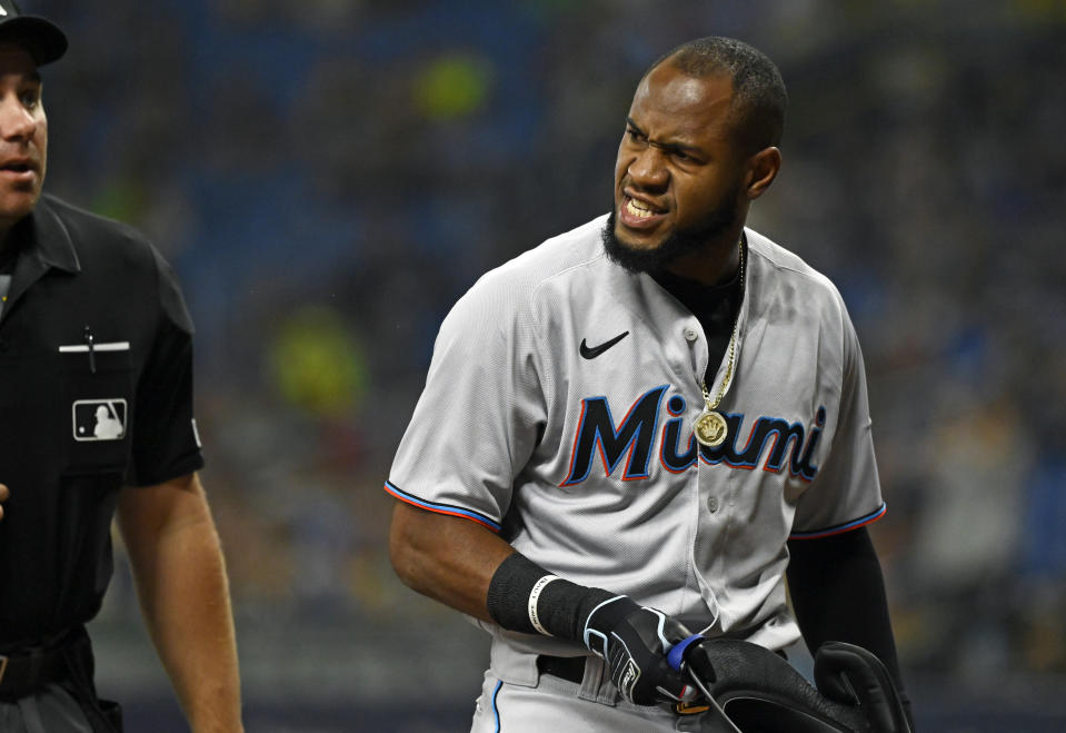 Miami Marlins' Bryan De La Cruz, right, yells at home plate umpire John Libka when he was ejected after striking out during the first inning of a baseball game against the Tampa Bay Rays, Friday, Sept. 24, 2021, in St. Petersburg, Fla. (AP Photo/Steve Nesius)