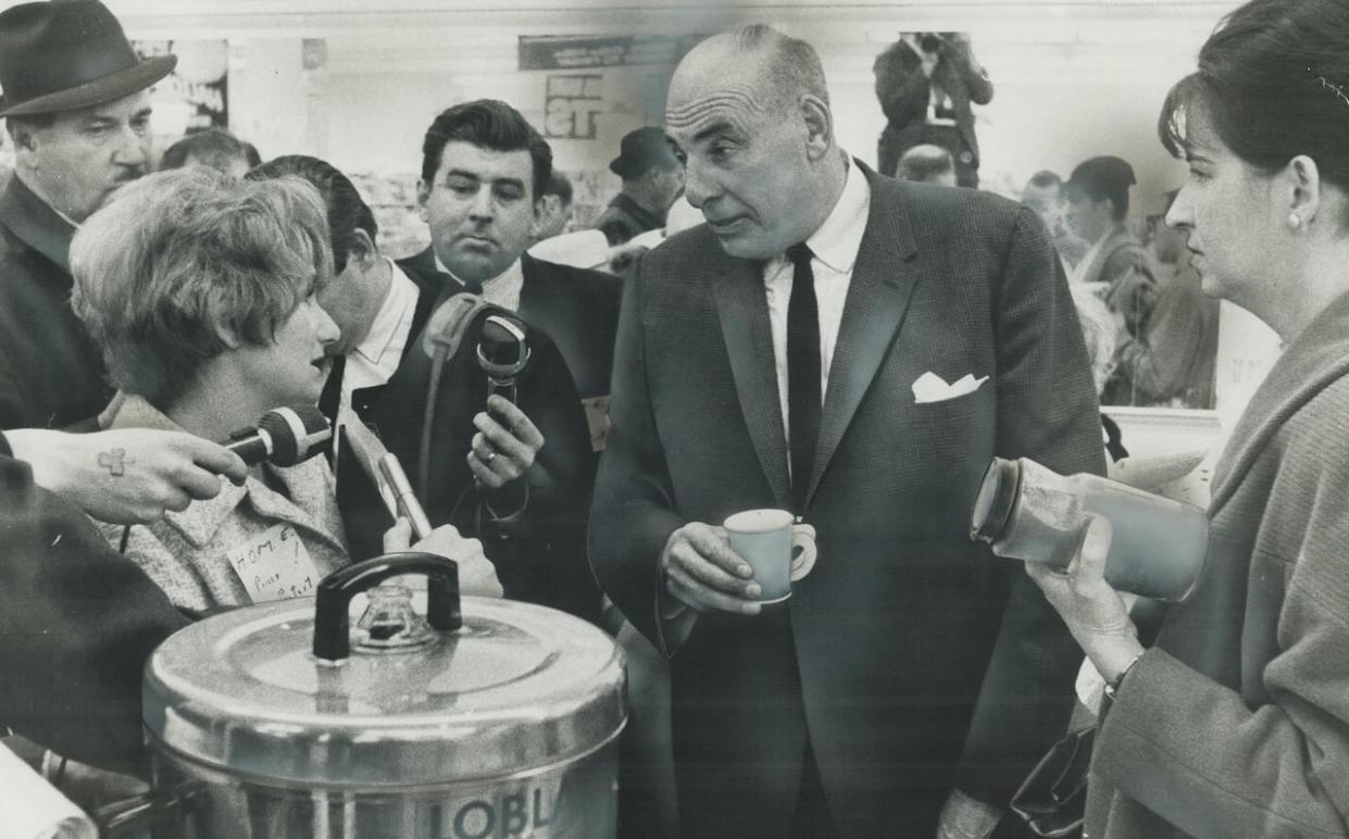 Loblaws vice-president F.W. Morley talks prices with protestors on Oct. 21, 1966, remaining unruffle and smiling while pouring coffee for housewives. (Barry Philp/Toronto Star/Getty Images - image credit)
