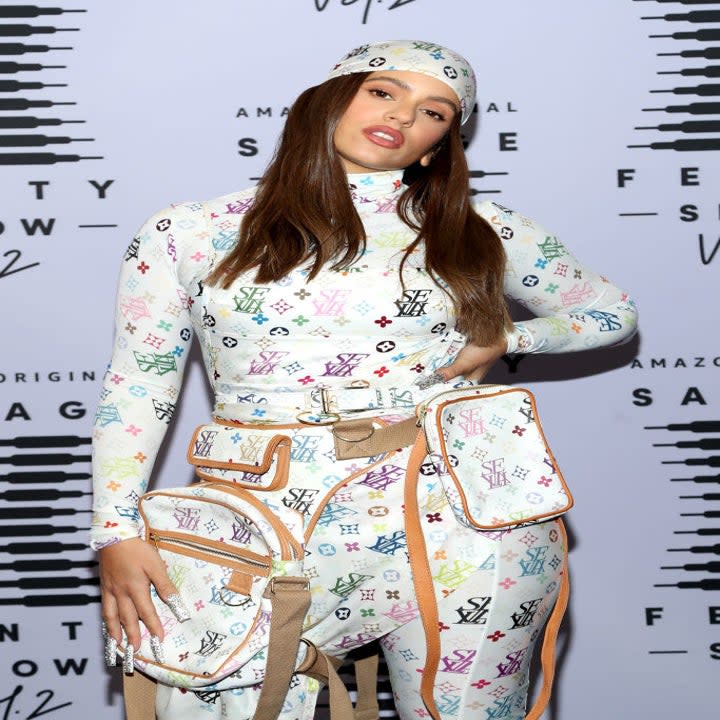 Rosalía a light colored Louis Vuitton logo printed bodysuit with matching bandana and backpack