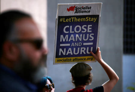 A protester from the Refugee Action Coalition holds a banners during a demonstration outside the offices of the Australian Government Department of Immigration and Border Protection in Sydney, Australia, April 29, 2016. REUTERS/David Gray