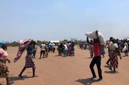 People are seen at a camp of an aid distribution for victims of Cyclone Idai, in Guara Guara, outside of Beira