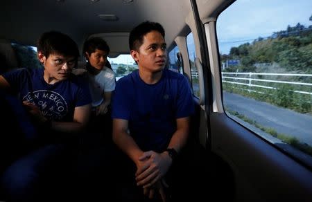 Tourists from Philippines and tour guide Takuto Okamoto (C) look out from a van inside the exclusion zone, near Tokyo Electric Power Co's (TEPCO) tsunami-crippled Fukushima Daiichi nuclear power plant, in Futaba town, Fukushima prefecture, Japan May 17, 2018. Picture taken May 17, 2018. REUTERS/Toru Hanai