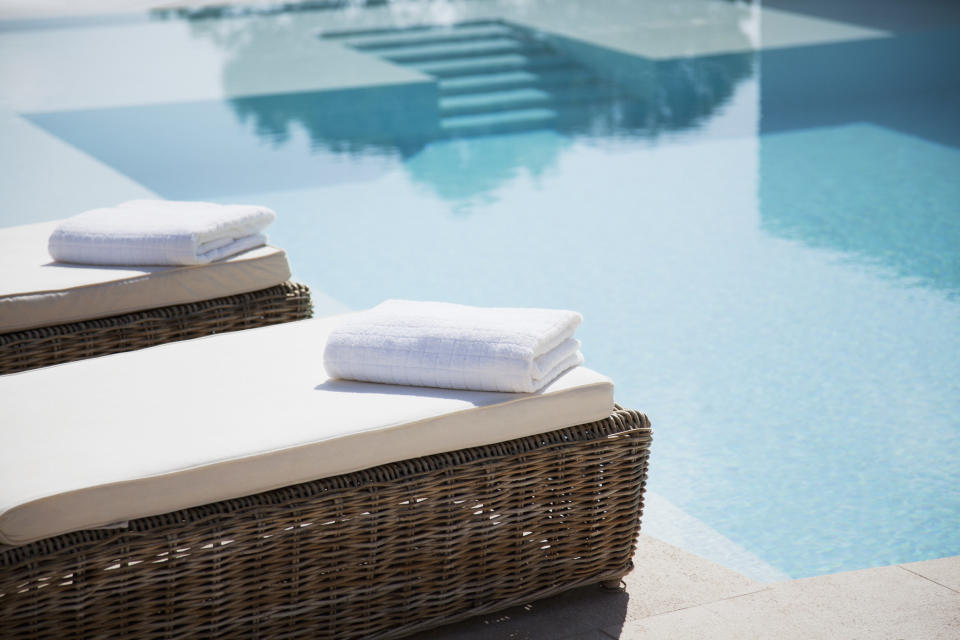 Lounge beds and towels next to a pool