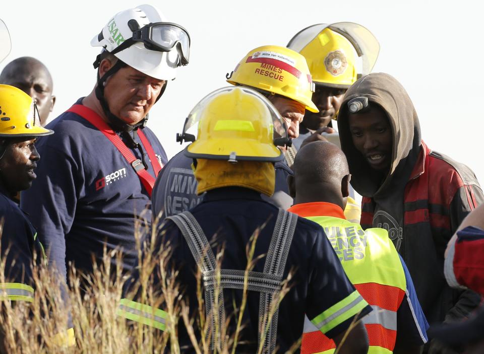 A suspected illegal miner talks to officials after being rescued from an abandoned gold shaft in Benoni