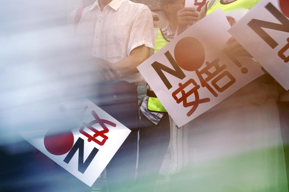 In this Aug. 8, 2019 photo, protesters with "No Abe!" signs stand during a rally outside Japanese Prime Minister Shinzo Abe's residence in Tokyo. South Korea and Japan have locked themselves in a highly-public dispute over history and trade that in a span of weeks saw their relations sink to a low unseen in decades. (AP Photo/Eugene Hoshiko)