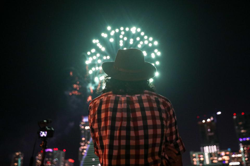 An Austin resident watches the annual Fourth of July fireworks display in Downtown Austin, Texas