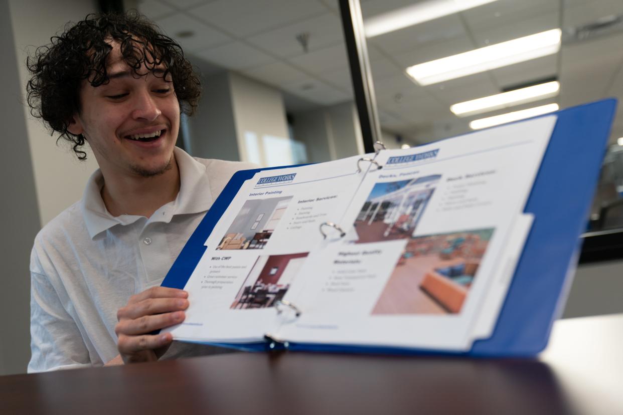 University of Kansas freshman Adam Brooks Jr. flips through a binder of information over what the College Works internship program offers during an interview Wednesday morning.