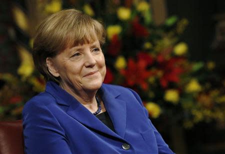 German Chancellor Angela Merkel smiles after addressing members of both Houses of Parliament in the Royal Gallery of the Palace of Westminster in London February 27, 2014. REUTERS/Luke Macgregor