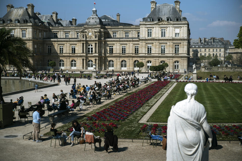 FILE - In this April 19, 2021, file photo people, some wearing face masks to prevent the spread of the coronavirus, enjoy the sun in an outdoor seating area in Luxembourg gardens, in Paris. Ties between the United States and its oldest ally, France, have long been fraternal, but they've also been marked by deep French unease over their equality. French concerns about being the junior partner in the relationship boiled over last week when the U.S., Britain and Australia announced a new security initiative for the Indo-Pacific. (AP Photo/Lewis Joly, File)