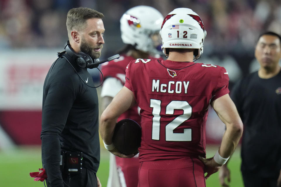 Arizona Cardinals head coach Kliff Kingsbury, left, speaks with quarterback Colt McCoy (12) during the first half of an NFL football game against the New England Patriots, Monday, Dec. 12, 2022, in Glendale, Ariz. (AP Photo/Ross D. Franklin)