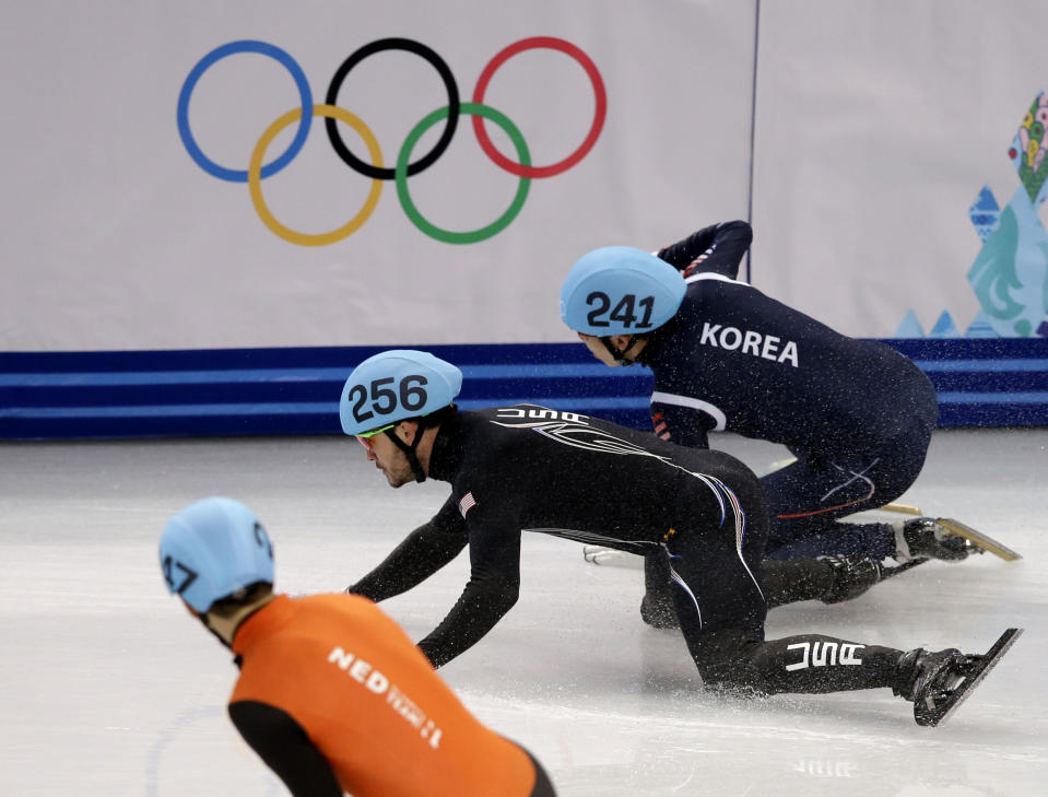 Lee Ho-suk of South Korea, right, and Eduardo Alvarez of the United States, centre, crash out in a men's 5000m short track speedskating relay semifinal at the Iceberg Skating Palace during the 2014 Winter Olympics, Thursday, Feb. 13, 2014, in Sochi, Russia. (AP Photo/Darron Cummings)