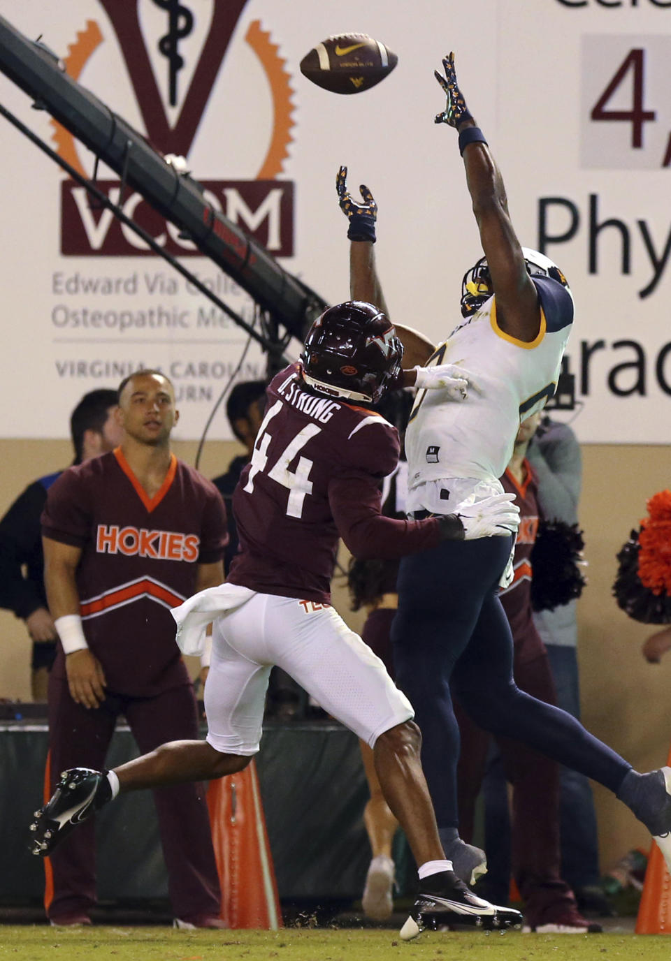West Virginia wide receiver Bryce Ford-Wheaton (0) attempts to catch a pass as Virginia Tech's Dorian Strong (44) defends during the first half of an NCAA college football game Thursday, Sept. 22, 2022, in Blacksburg, Va. (Matt Gentry/The Roanoke Times via AP)