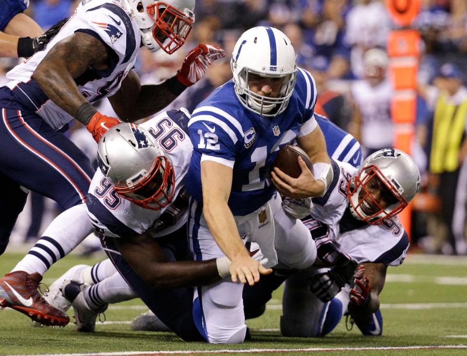 In this Sunday, Oct. 18, 2015, file photo, then-Indianapolis Colts quarterback Andrew Luck (12) is sacked by New England Patriots defensive end Chandler Jones (95) and defensive tackle Dominique Easley (99) in the second half of an NFL football game in Indianapolis.