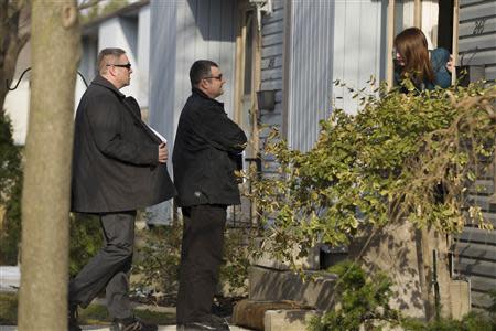 Royal Canadian Mounted Police (RCMP) investigators canvas the London, Ontario neighbourhood April 16, 2014, around the home of Stephen Solis-Reyes who has been charged in connection with exploiting the "Heartbleed" bug to steal taxpayer data from a government website. REUTERS/Geoff Robins