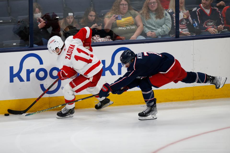 Detroit Red Wings' Filip Zadina, left, skates past Columbus Blue Jackets' Sean Kuraly during the third period of a preseason NHL hockey game Wednesday, Oct. 6, 2021, in Columbus, Ohio. (AP Photo/Jay LaPrete)