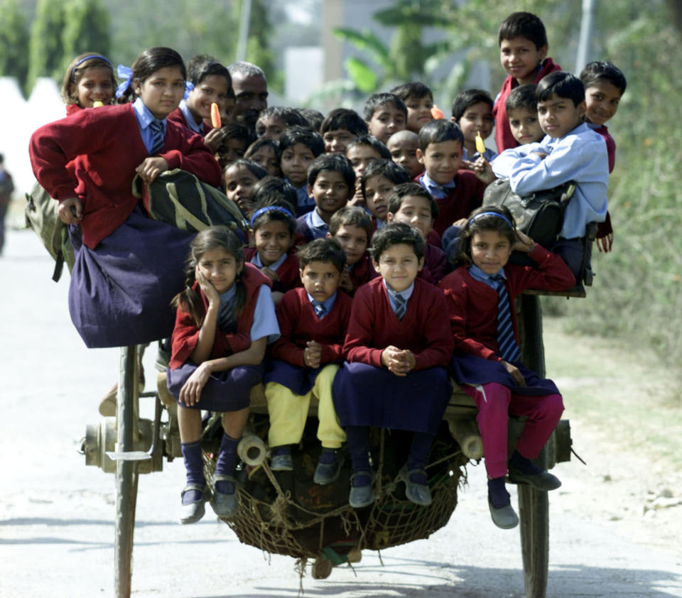 Des enfants indiens sont amenés à l’école dans la banlieue de New Delhi.