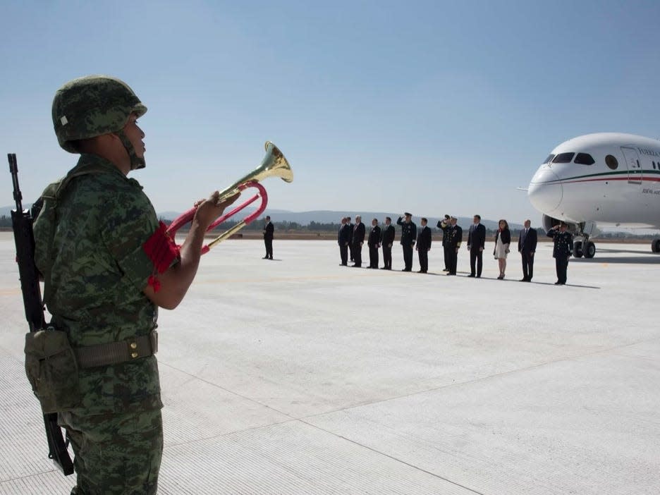 Enrique Pena Nieto with first lady Angelica Rivera Hurtado in front of the Boeing 787, with guards.