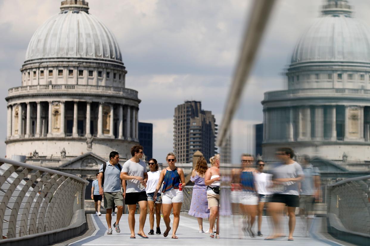 People walk over The Millennium Bridge away from St Paul's Cathedral in London on June 26, 2020, as temperatures are expected to again be high, hitting 31 degrees Celsius in London. - Britons were on Friday urged to abide by social distancing rules over fears over a coronavirus resurgence after tens of thousands of people descended on beaches during a heatwave. (Photo by Tolga AKMEN / AFP) (Photo by TOLGA AKMEN/AFP via Getty Images)