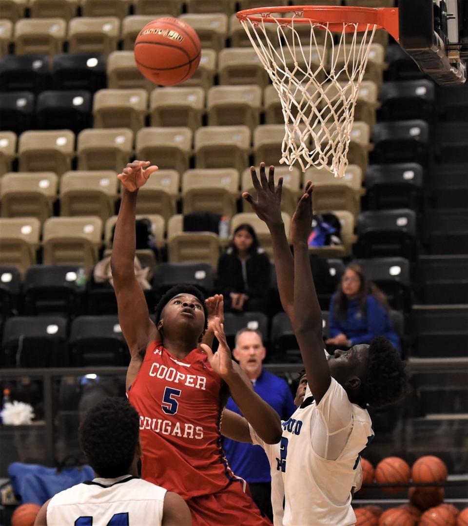 Cooper's Maxwell Falade (5) shoots over Amarillo Palo Duro's Walid Abdelrahim, right, in the first half.