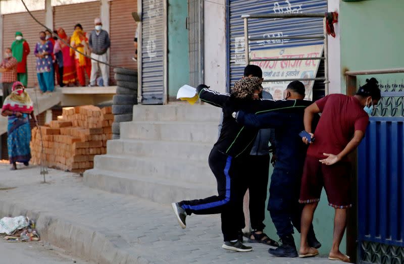 A local protester punches a man during an argument about Indonesians taking shelter at the mosque, amid fear of outsiders spreading coronavirus disease (COVID-19), at Jame Masjid in Imadol, Lalitpur