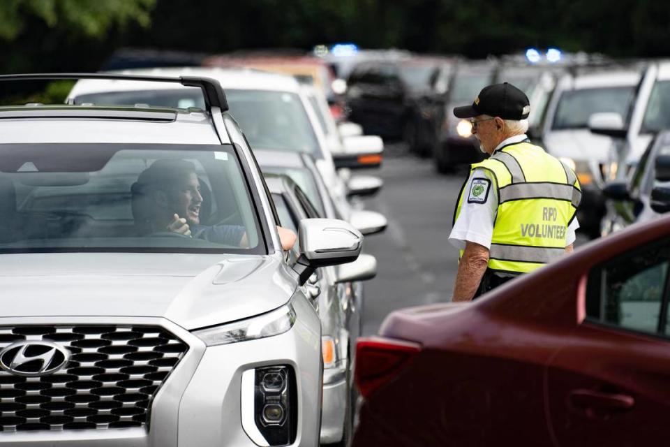 Joe O’Hagan, a Raleigh Police Department volunteer, talks with a participant in line at the Raleigh gun buy back event at Mount Peace Baptist Church on Saturday, Aug. 20, 2022.