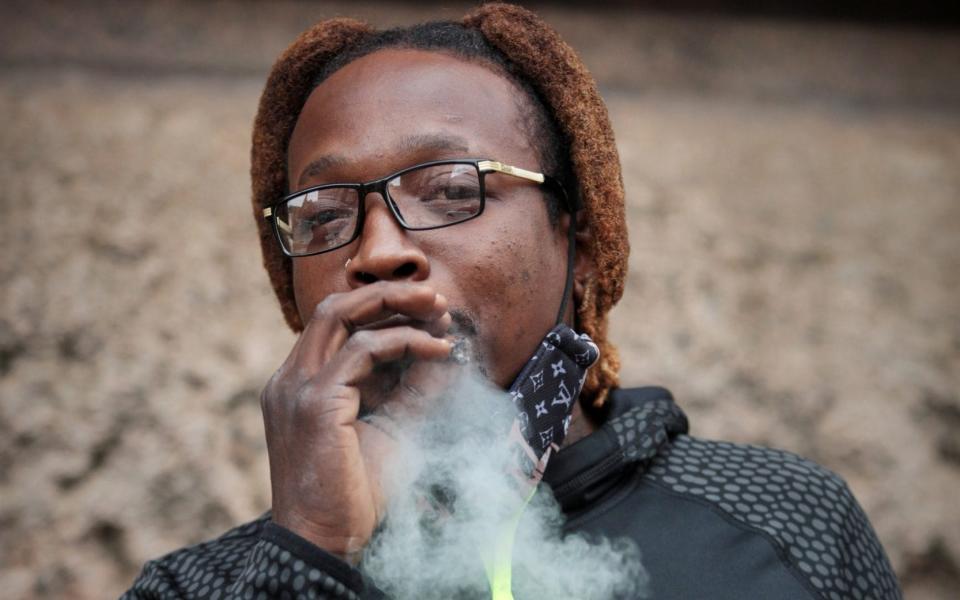 DeAndre, 32, smoking a joint in Baltimore - Dan Callister for The Telegraph